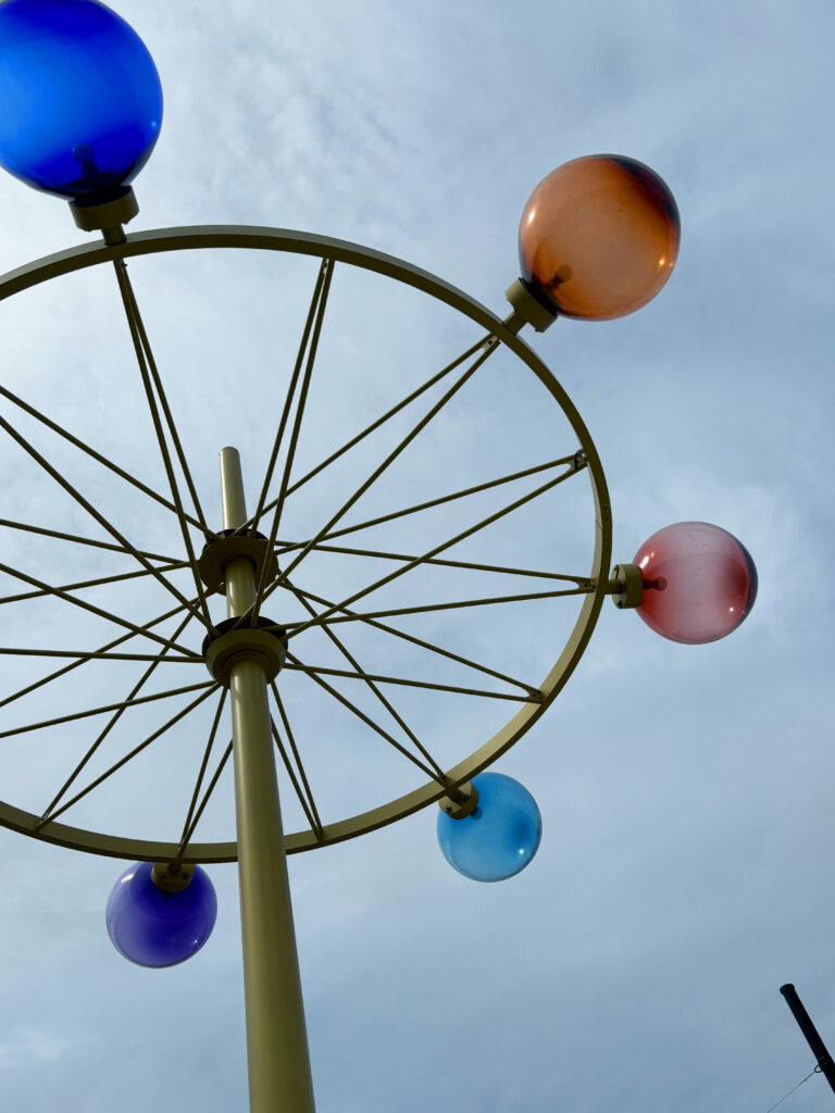 Konstverk med olikfärgade glober av glas på en sex meter hög metallstolpe.